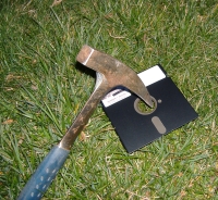 Photograph of geology pick through the center of an old 5.25 inch floppy disk